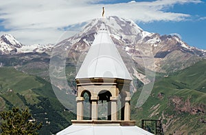 Kazbek 5054m mountain view with Gergeti village through the architectural arches of the chapel in Prophet Elijah Fathers Monastery
