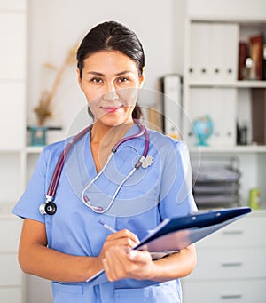 Kazhahstani female medic in uniform standing in doctor`s office