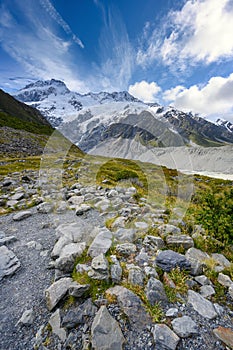 Kea Point Track in Mount Cook National Park, high rocky mountains and green grass
