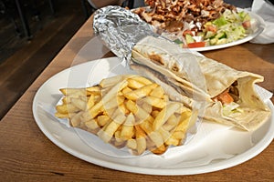 Kebab and French fries recipe on white dish table in an European country