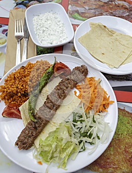 Kebab served in the plate with yogurt salad.