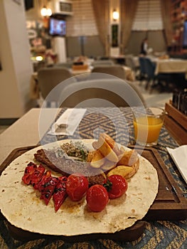 Kebab with tomato and meat and orange juice on the table of the restaurant at Istambul when dinner time