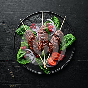 Kebab. Traditional middle eastern, arabic or mediterranean meat kebab with vegetables and herbs. Top view.