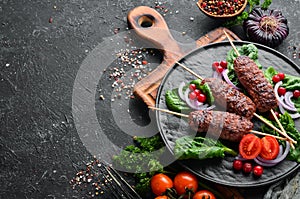 Kebab. Traditional middle eastern, arabic or mediterranean meat kebab with vegetables and herbs. Top view. photo