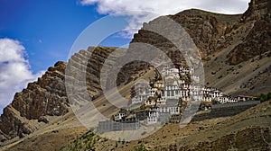 Kee Gompa Buddhist monastery in India surrounded by dry brown hills and cliffs under a bright sky