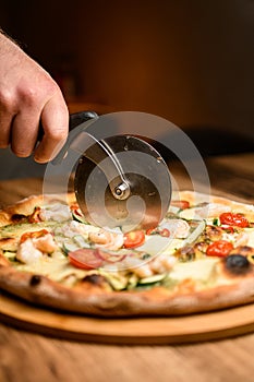 Pizza precision. Chef slices with special knife for enjoyment.