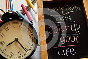 Keep calm and color up your life on phrase colorful handwritten on chalkboard, alarm clock with motivation and education concepts