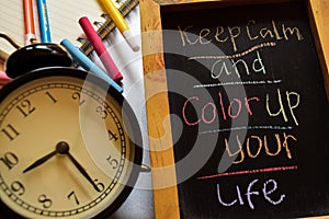 Keep calm and color up your life on phrase colorful handwritten on chalkboard, alarm clock with motivation and education concepts