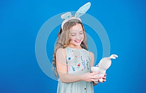 Keep calm and happy Easter. Little girl and rabbit toy. Small girl in rabbit ears with Easter toy. Little child in