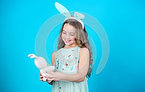 Keep calm and happy Easter. Little girl and rabbit toy. Small girl in rabbit ears with Easter toy. Little child in