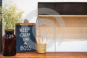 Keep Calm like a Boss hand drawing with chalk on blackboard on working office desk. Motivational Chalkboard Quotes