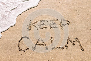 Keep calm written in the sand seashore of tropical beach