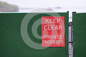 Keep clear private property sign red on green steel closed shut gate exclusive estate Loch Lomond Scotland