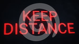Keep distance warning banner. Red pixel text on old dusty screen