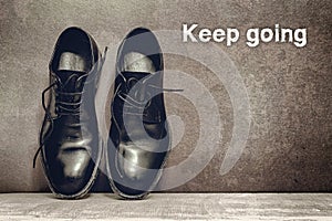 Keep going on brown board and work shoes on wooden floor