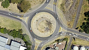 Keep on going until you get there. 4k drone footage of vehicles driving around a traffic circle in Cape Town, South