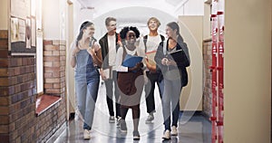 Keep learning, keep moving forward. Shot of a group of teenagers walking down the hall at high school.