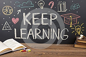 Keep learning written on chalkboard. Concept of knowledge, improvement, development and keeping up the motivation to learn new