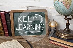 Keep learning written on chalkboard. Concept of knowledge, improvement, development and keeping up the motivation to learn new
