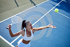 Keep moving forward. an attractive young woman playing tennis outside.