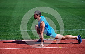 Keep moving. sportsman relax. athlete train his flexibility. be flexible. man doing stretching exercise on stadium