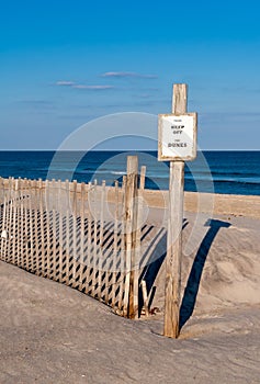 A Keep Off sign and fence on fragile sand dunes