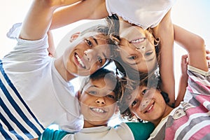 We keep our family circle close knit. Low angle portrait of a group of happy siblings huddled together outdoors.