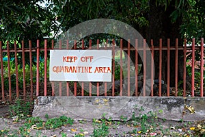 Keep Out Quarantine Area handmade banner sign on metallic fence. COVID-19 hospital surrounding wall