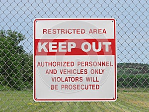 Keep out sign on a chain link fence.