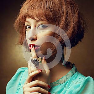 Keep secret concept. Portrait of young orient eastern girl with fashionable accessories showing SH! wheesht, keep silence.