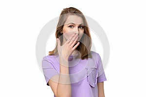 Young woman covering mouth with hand, looking serious, promises to keep secret. Silence and secret concept