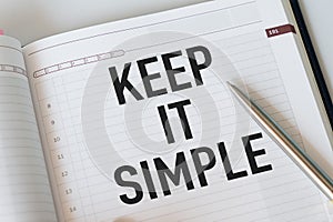 Keep it simple. A paper note with the phrase Keep it simple on it with some crumpled paper balls around it. Close up