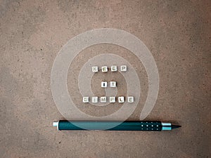 'Keep It Simple' phrase with pen on the cardboard.