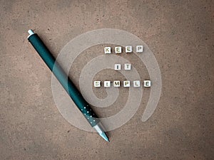 'Keep It Simple' phrase with pen on the cardboard.