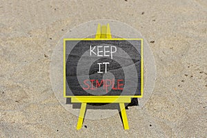 Keep it simple symbol. Concept word Keep it simple on beautiful black chalk blackboard. Sand beach. Beautiful sand beach