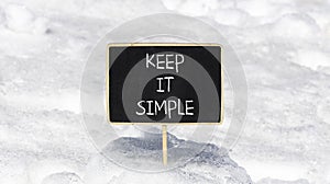 Keep it simple symbol. Concept word Keep it simple on beautiful black chalk blackboard. White snow. Beautiful white snow