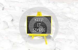 Keep it simple symbol. Concept word Keep it simple on beautiful black chalk blackboard. White snow. Beautiful white snow