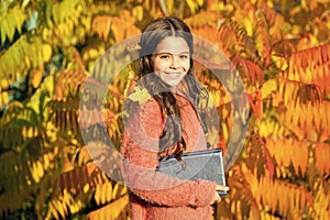 Keep studying. Little child enjoy learning in autumn park. Kid study with book. Small girl read book on autumn day