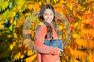 Keep studying. Small girl read book on autumn day. Autumn literature concept. Small child enjoy reading autumn foliage