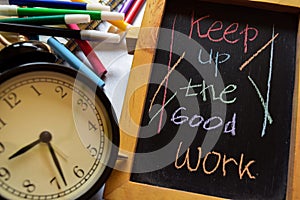 Keep up the good work on phrase colorful handwritten on chalkboard, alarm clock with motivation and education concepts