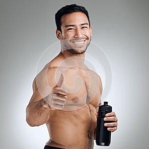 Keep up the good work and soon youll see the results. an athletic man holding a bottle of water while standing against a