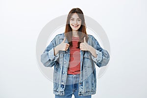 Keep up, you are doing great. Satisfied confident joyful woman in streetstyle denim jacket, showing thumbs up and