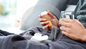 Keep your fluid intake up and your exertion levels low. an unrecognisable man taking medication while recovering from an
