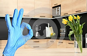 Keep your home virus-free. Woman showing Ok in kitchen
