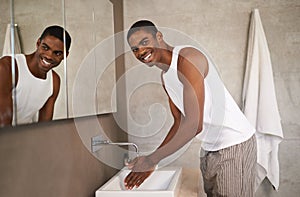 Keeping clean. A young man washing his hands.