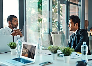 Keeping it corporate. two businessmen having a discussion in an office.