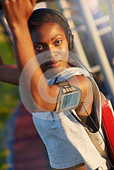 Keeping her body in tiptop shape. A young woman using outdoor exercise equipment at the park.