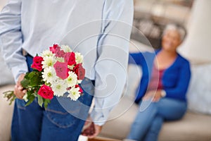 Keeping love alive. a senior woman receiving a surprise bunch of flowers from her husband.