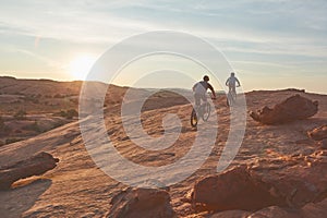 Keeping in prime shape. Full length shot of two young male athletes mountain biking in the wilderness.