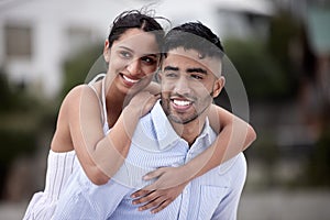 Keeping the romance alive. Cropped shot of a handsome young man piggybacking his girlfriend along the beach.